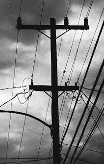 ominus photograph of powerlines-- with storm clouds in the background